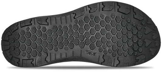 Underside view of black sandal to show the tread on white background