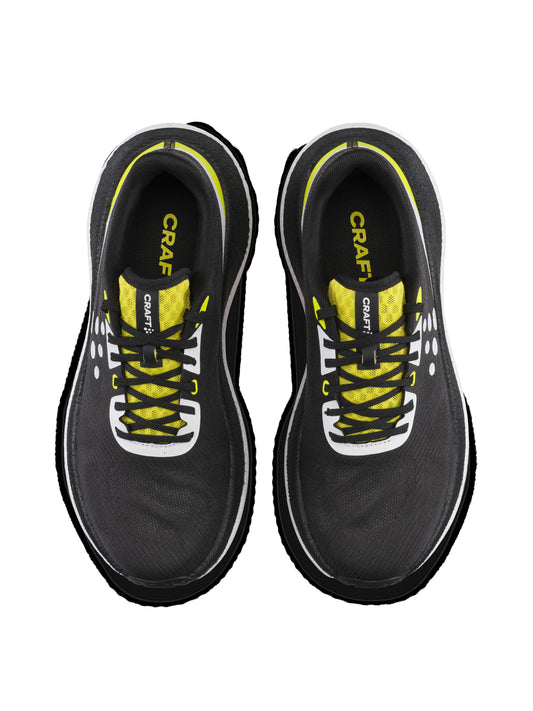 Overhead view of shoes with black upper, yellow details, and white sole on white background