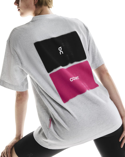 Back of person wearing a grey t-shirt with black and pink On Court design on the back