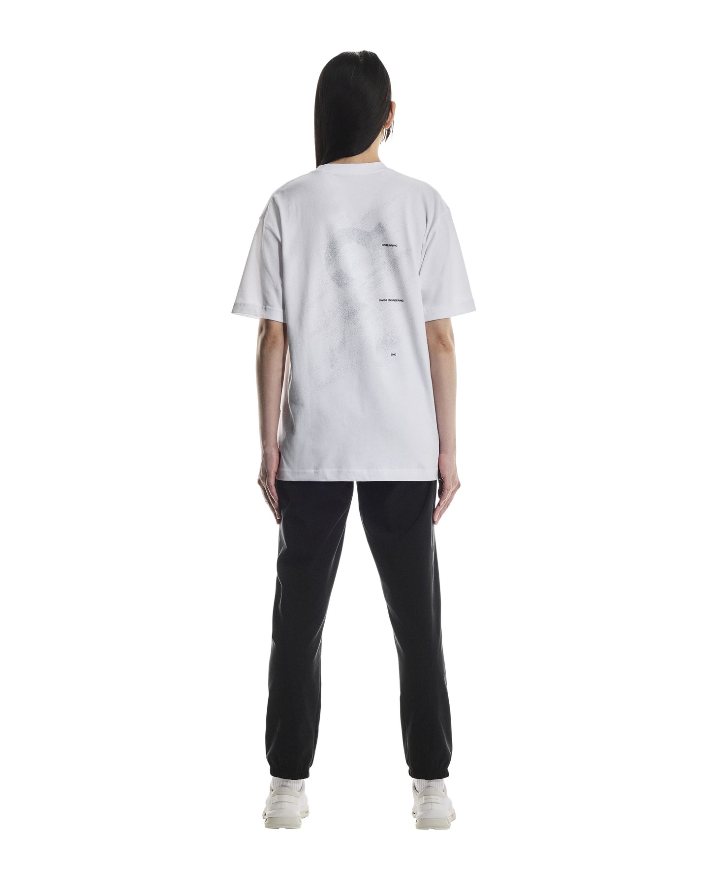 Rear side of Person wearing a white t-shirt and black pants on a white background
